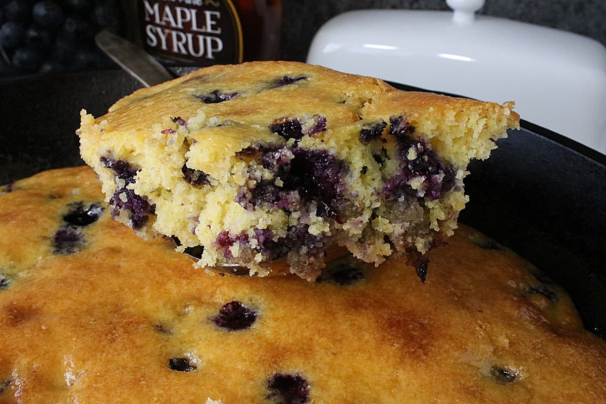 A golden brown spoonful of Cornbread Breakfast Casserole with Sausage and Blueberries.