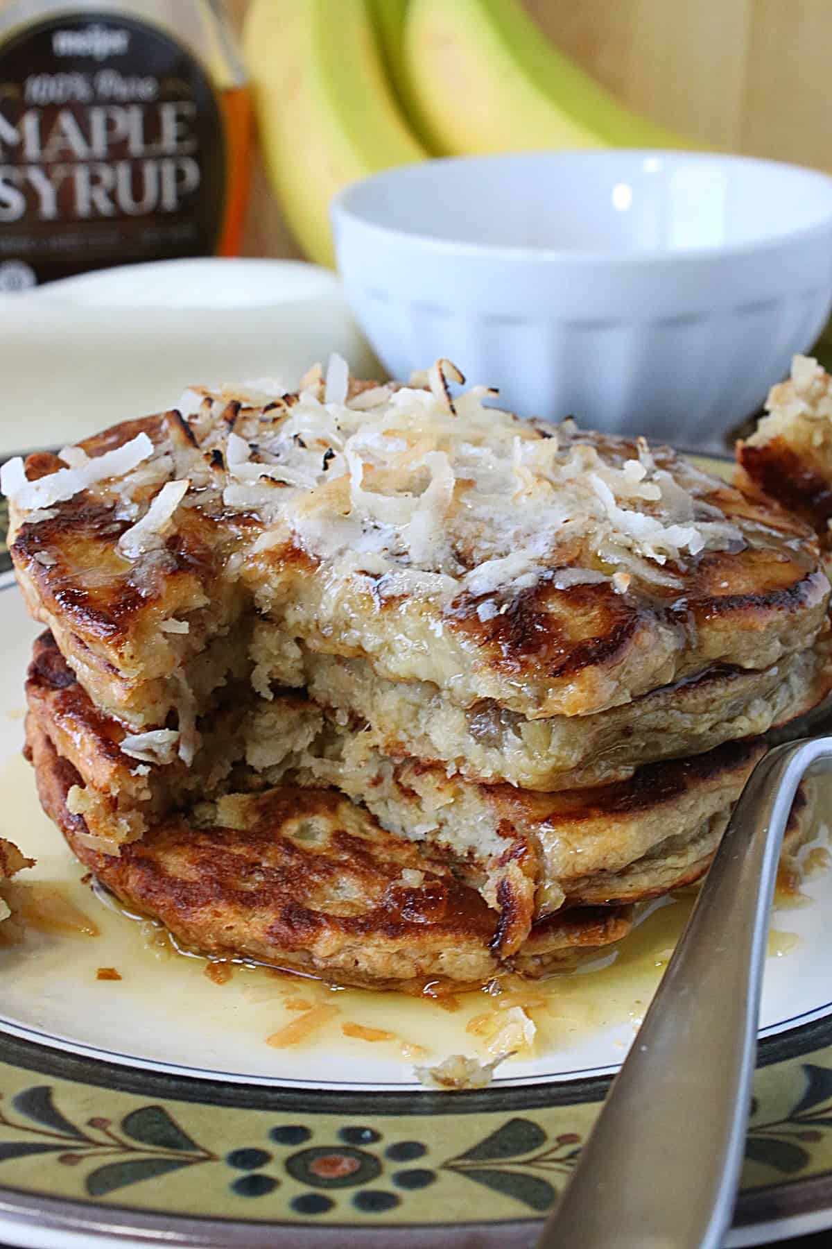 A gorgeous stack of Oat Pancakes with a bite taken out.