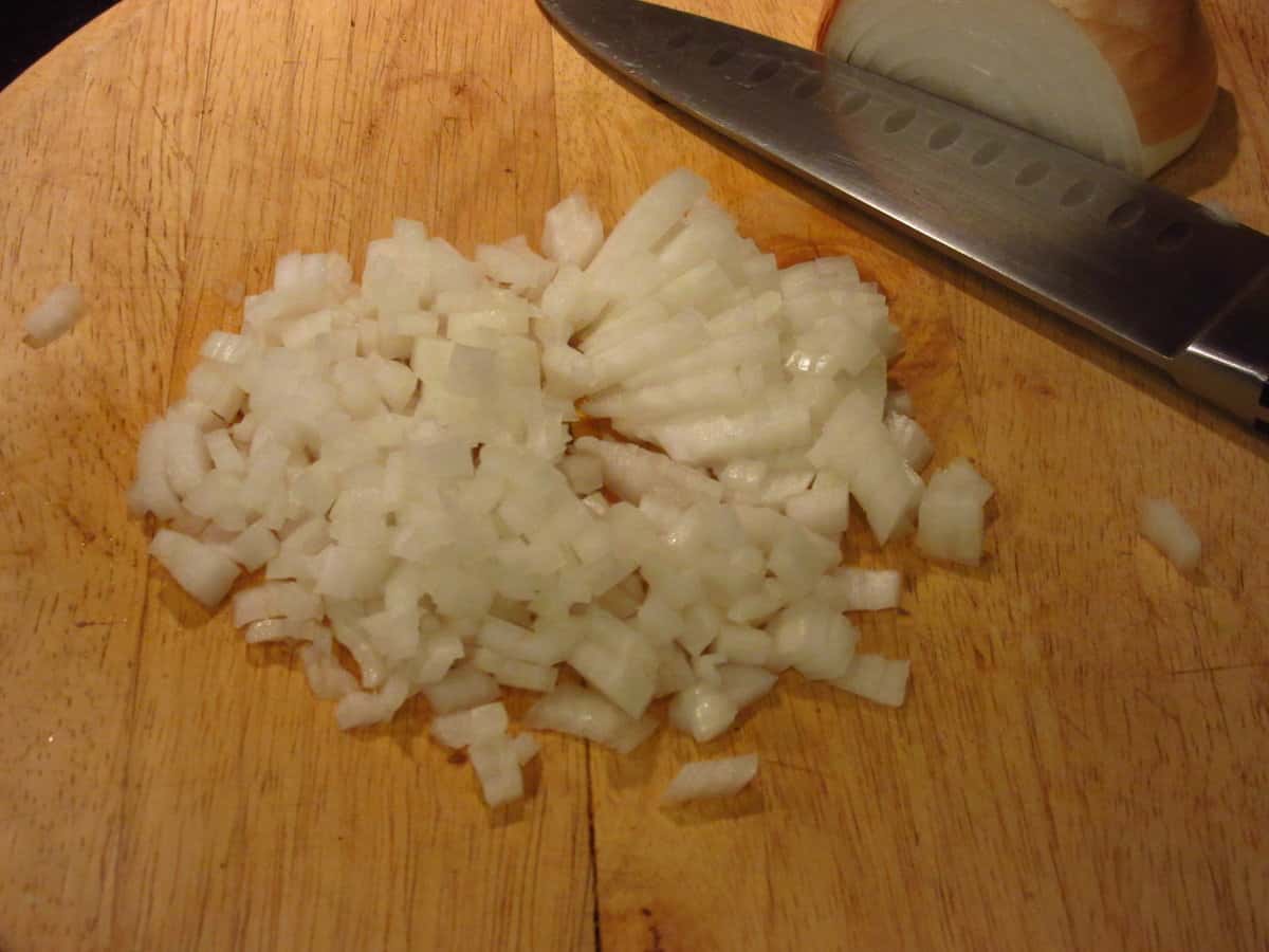 Chopped onions on a cutting board.