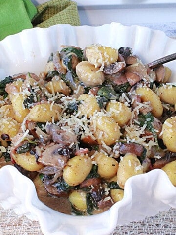 Potato Gnocchi with Spinach and Mushrooms in a pretty white bowl.