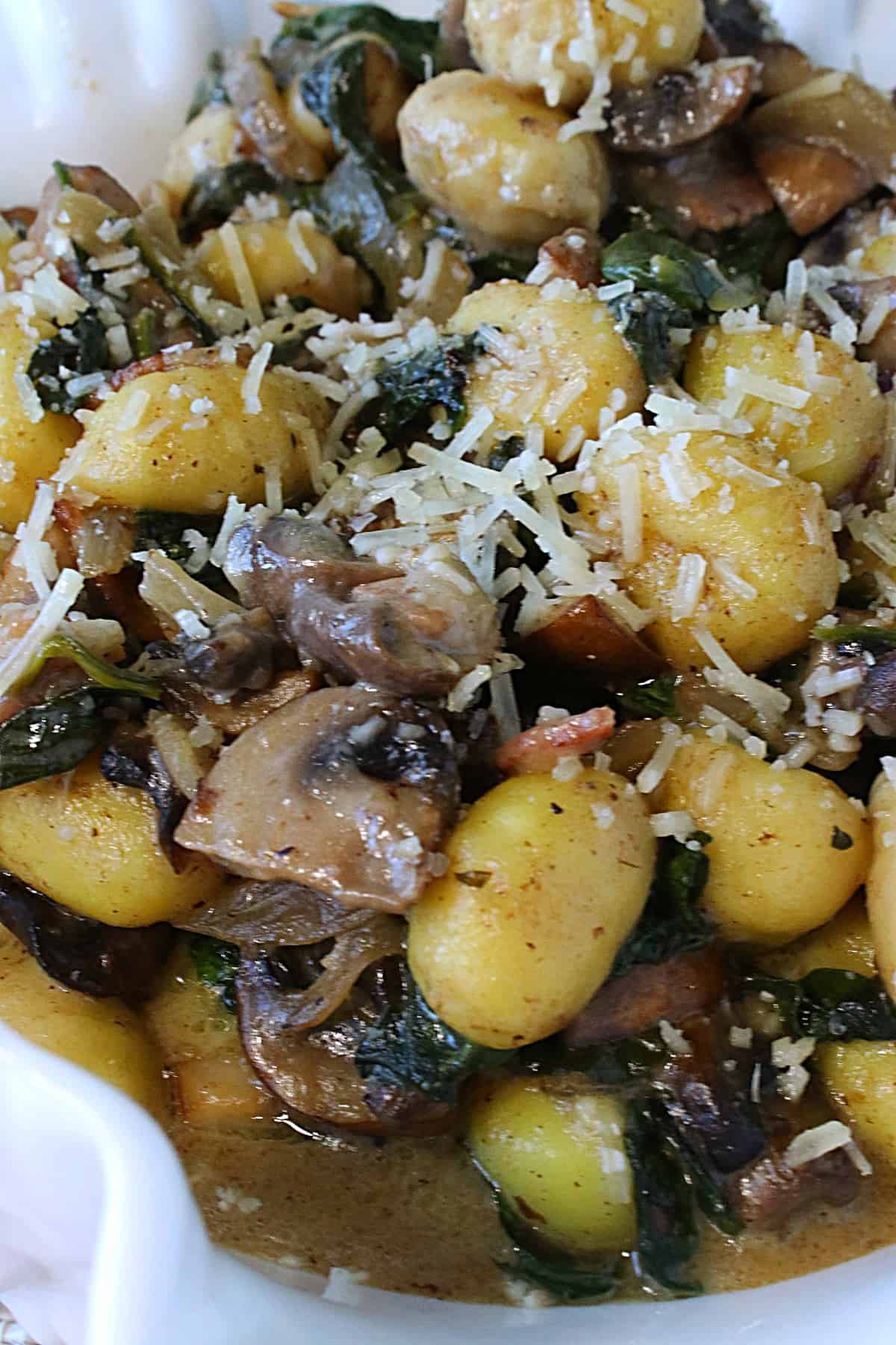Grated Parmesan on top of Potato Gnocchi with Spinach and Mushrooms.