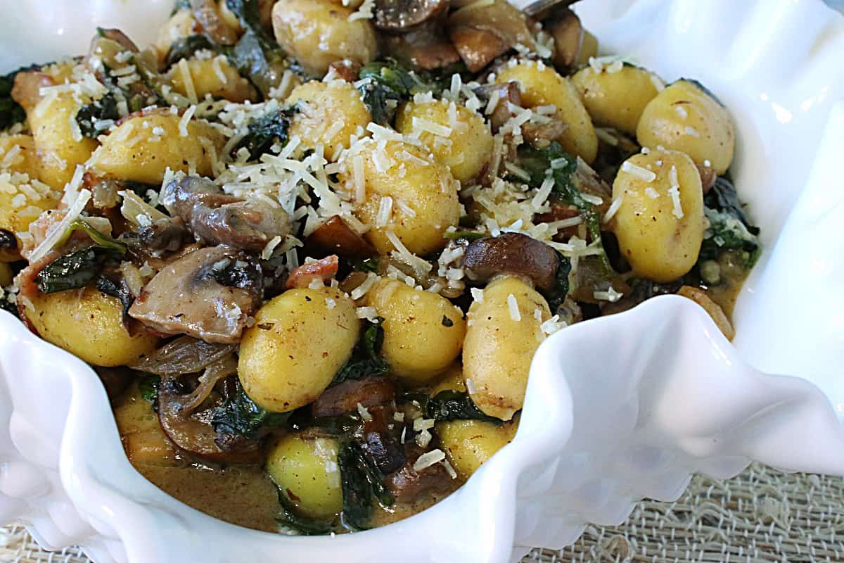 A closeup of a bowl of Potato Gnocchi with Parmesan cheese on top.