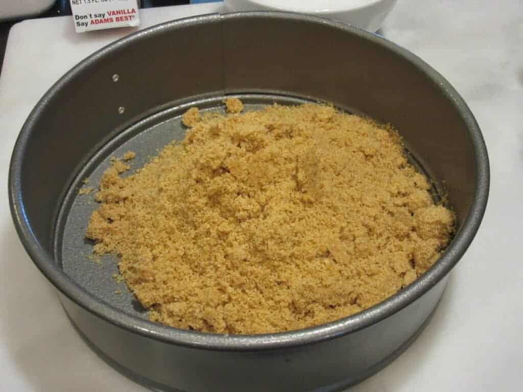 Graham cracker crumbs in a springform pan.