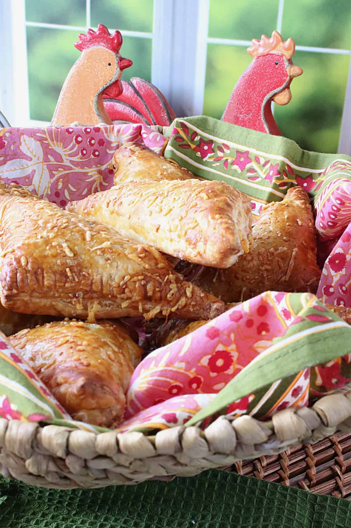 A basket filled with Chicken Pot Pie Turnovers by a window.