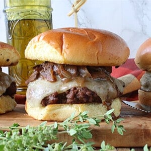 A delicious looking Mushroom Swiss Burger with melted cheese and caramelized onions and fresh thyme.