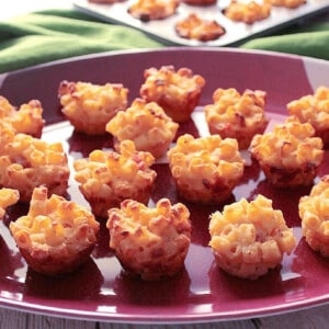 A football shaped tray filled with Ham and Macaroni and Cheese Appetizer Bites.