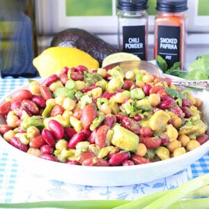 A vibrant bowl of Avocado and Kidney Bean Salad with a serving spoon.