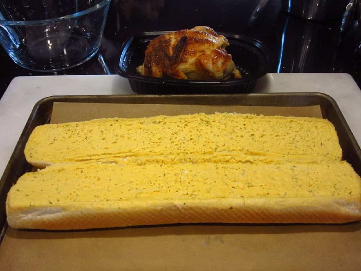 Garlic bread on a baking sheet with parchment paper before baking.