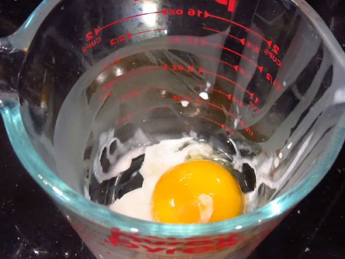 An egg in glass measuring cup.
