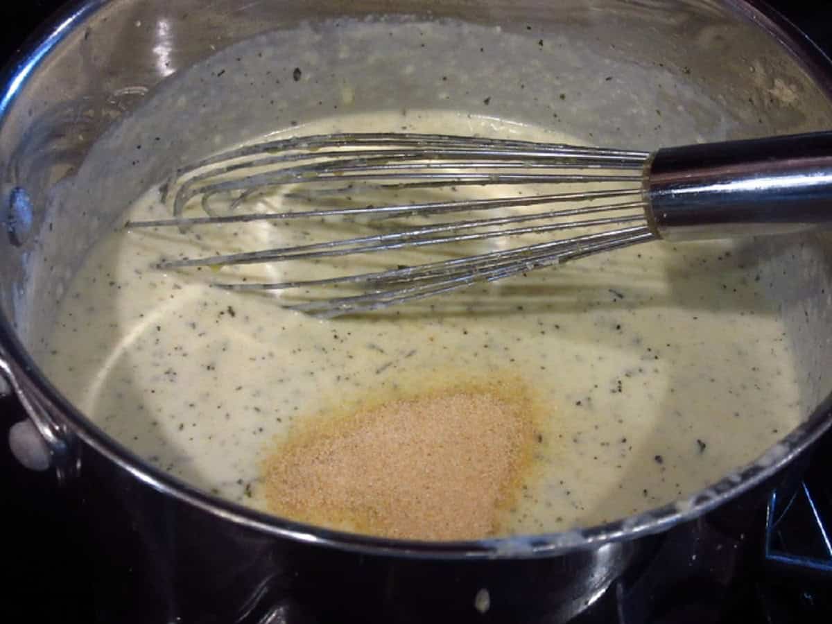 Garlic powder in a saucepan of alfredo sauce.