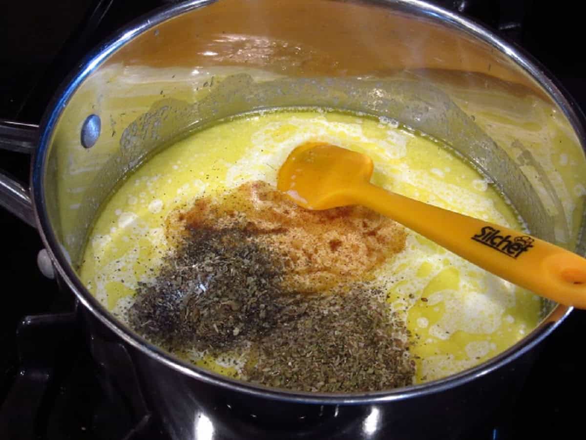 Spices and seasonings in a saucepan making homemade Alfredo sauce.