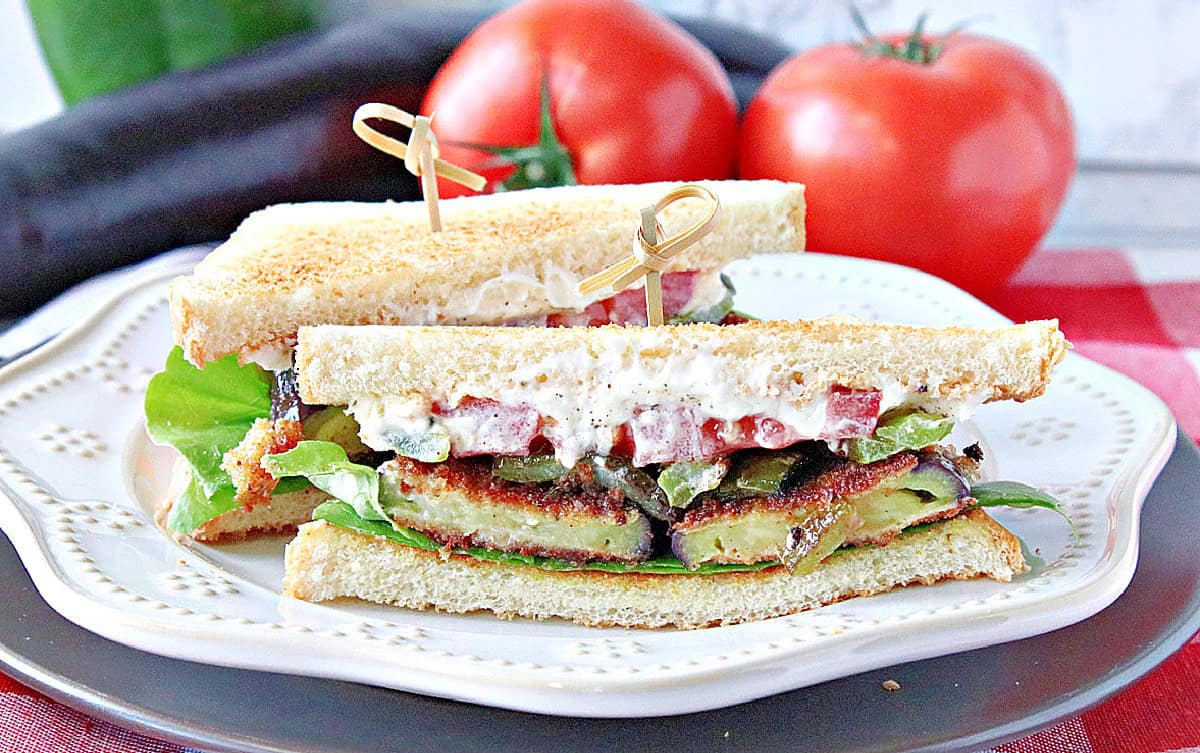 A colorful Fried Eggplant Sandwich with tomato, mayo, lettuce, and toast.