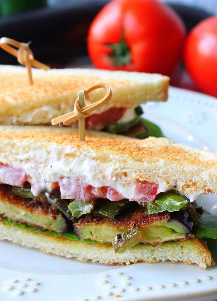 A colorful Fried Eggplant Sandwich that's been cut in half.