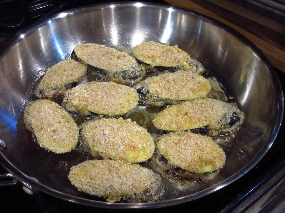 Pan frying breaded eggplant slices for fried eggplant sandwiches.
