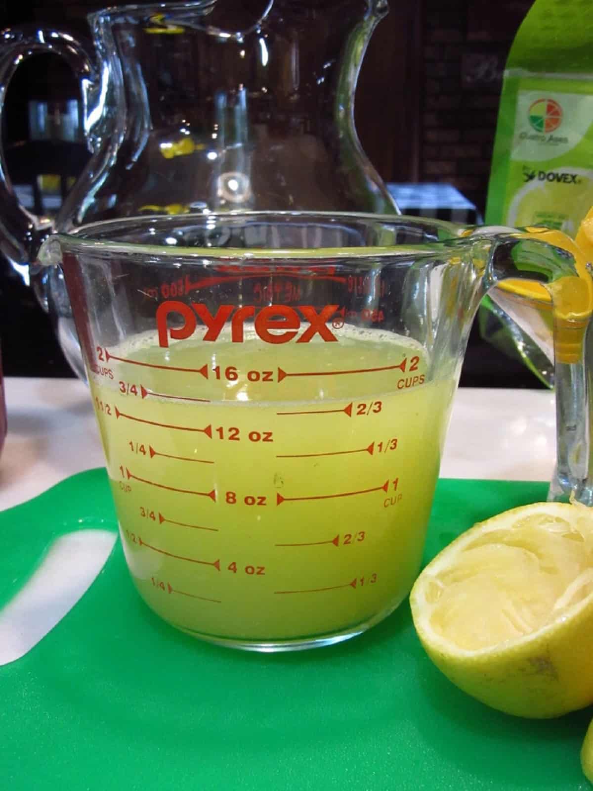 Fresh lemon juice in a glass measuring cup.