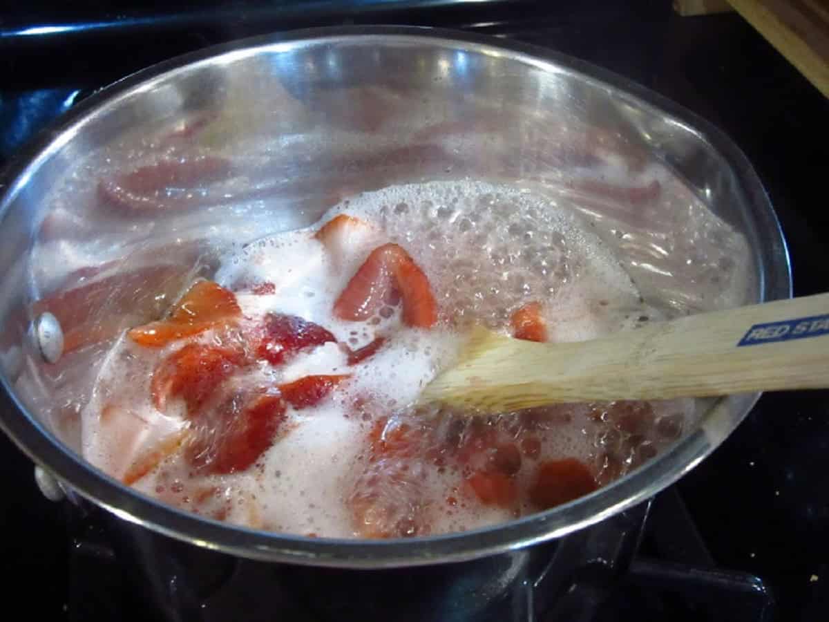 A bubbling saucepot of strawberry simple syrup.