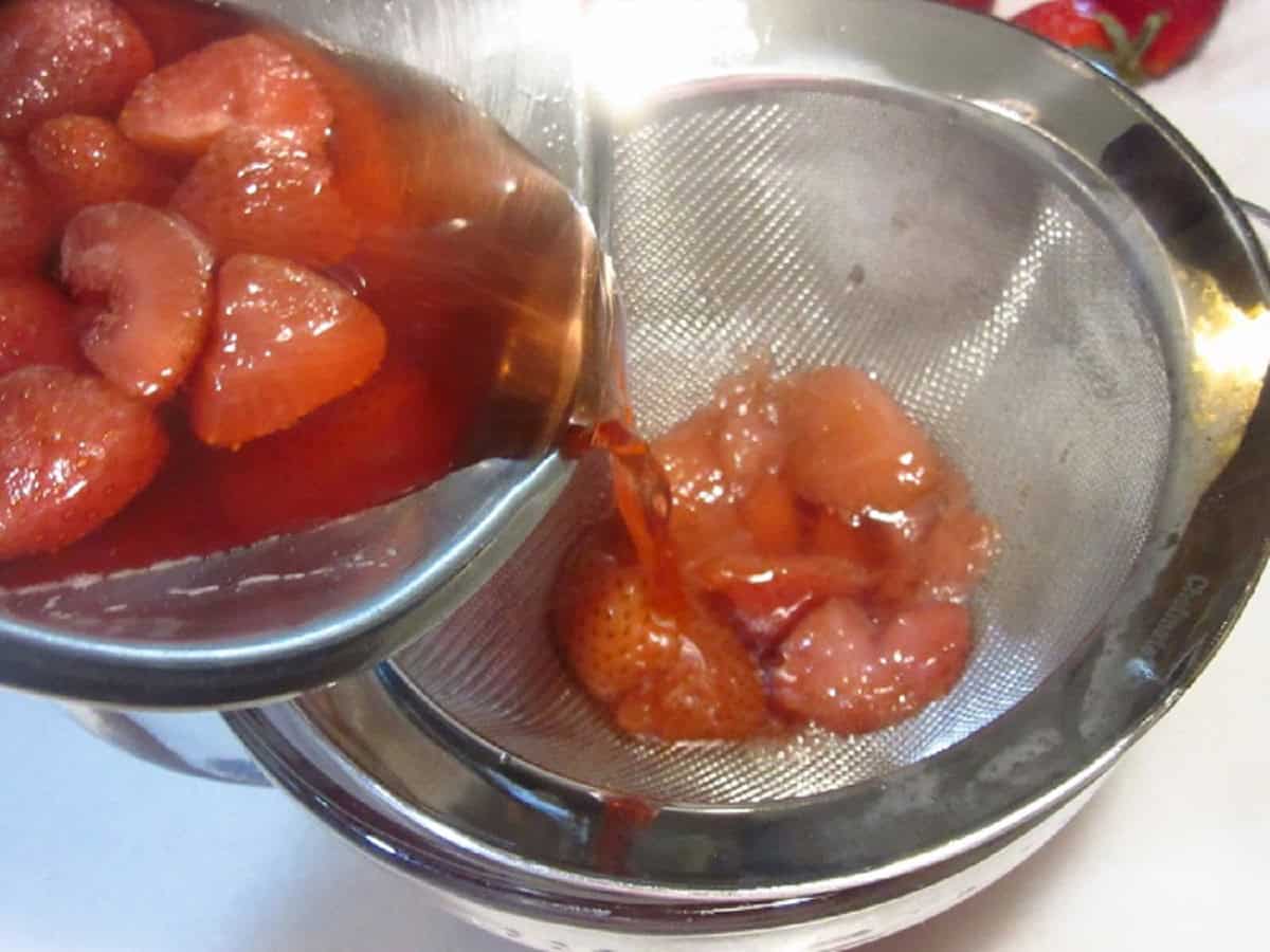 Straining strawberry simple syrup.