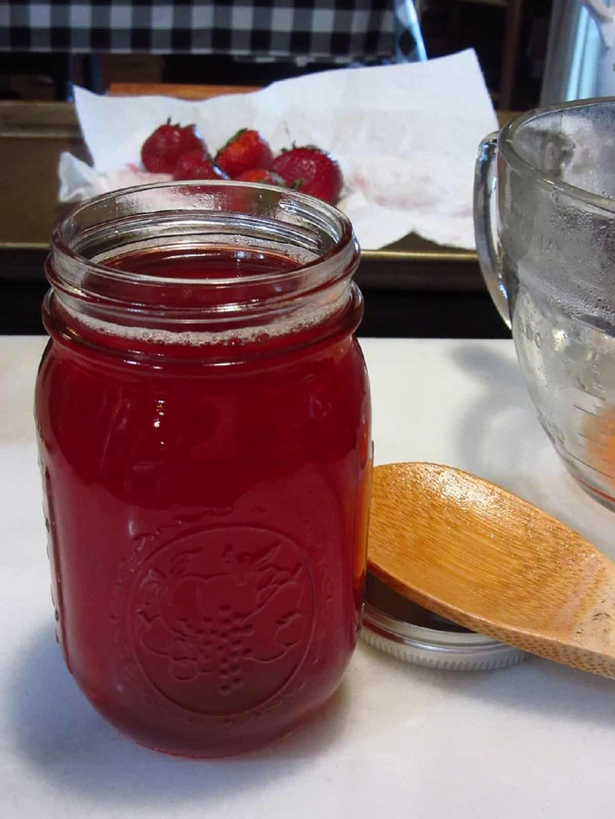 A mason jar filled with strawberry simple syrup.