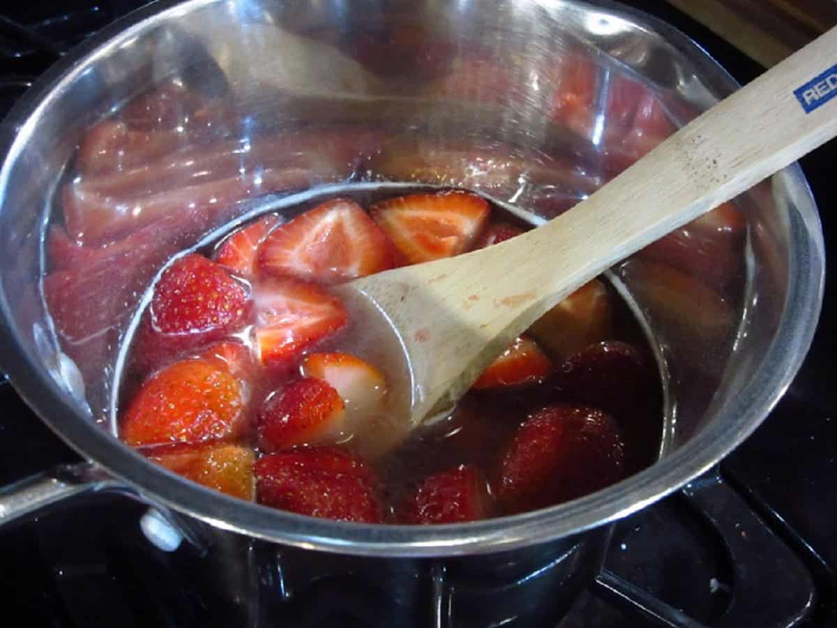 Chopped strawberries in a saucepan making simple syrup.