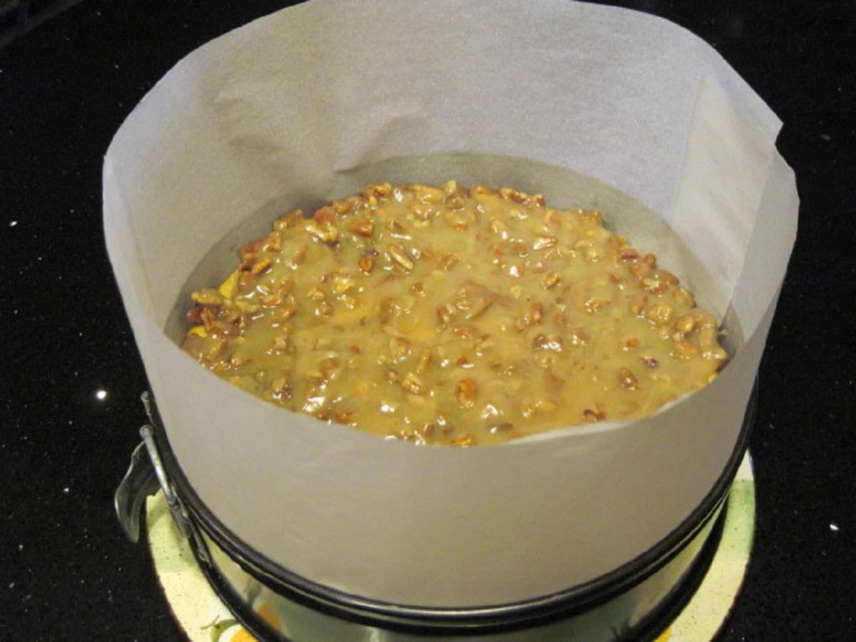 A Maple Pumpkin Cheesecake with a parchment collar.