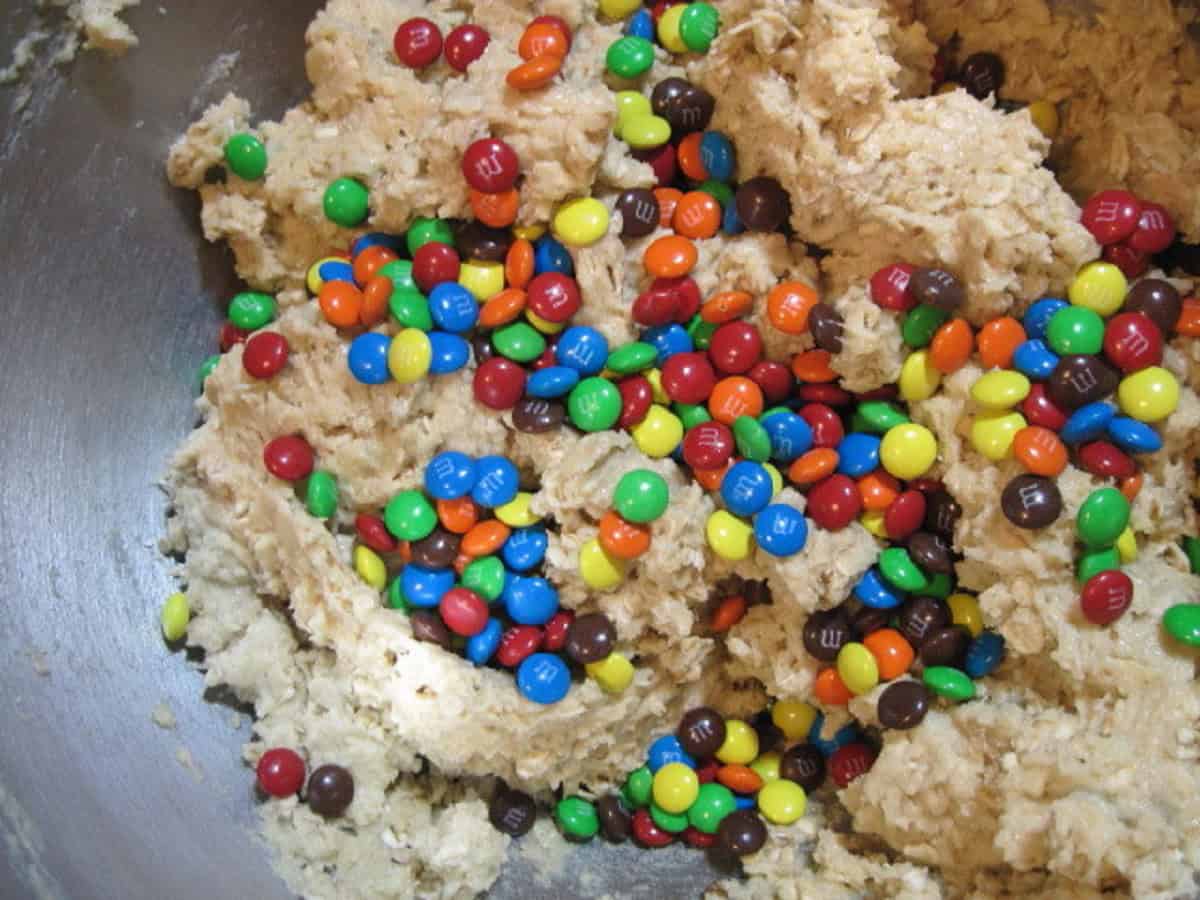 Mini m and m's in cookie dough in a bowl.