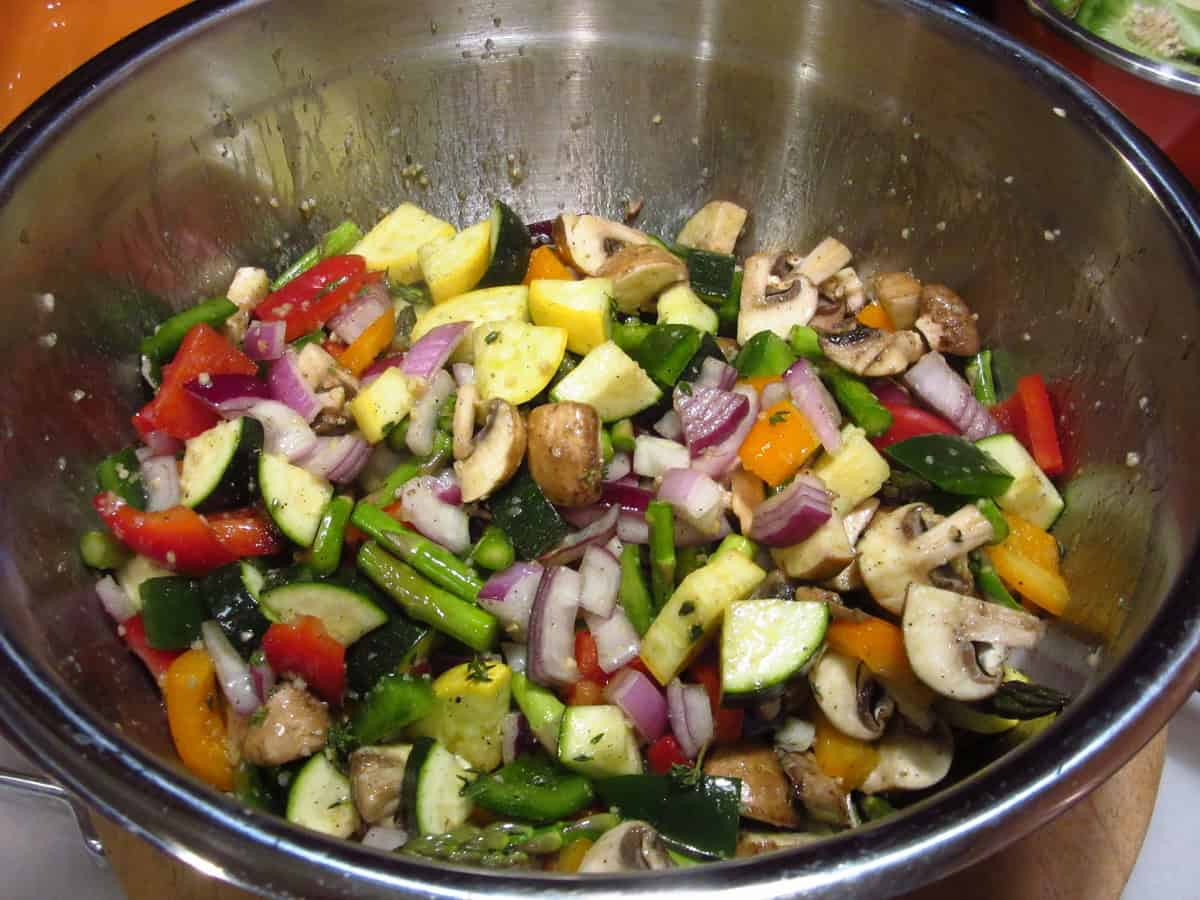 Mixed chopped rainbow vegetables in a stainless steel bowl.