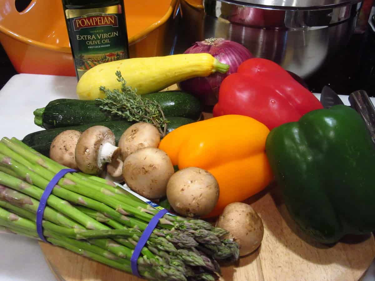 Rainbow vegetables on a cutting board to make roasted rainbow summer vegetables.