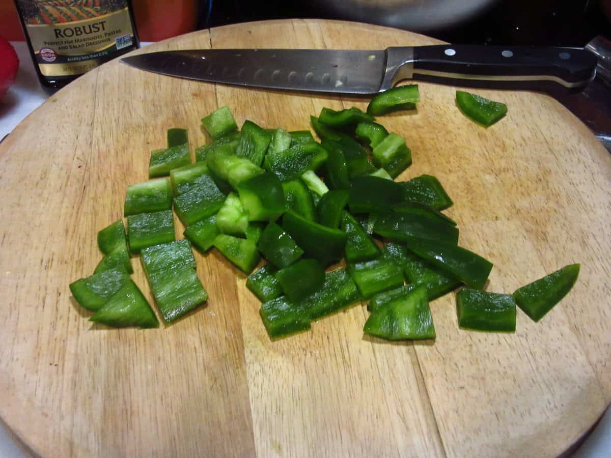 Chopped green peppers on a cutting board.