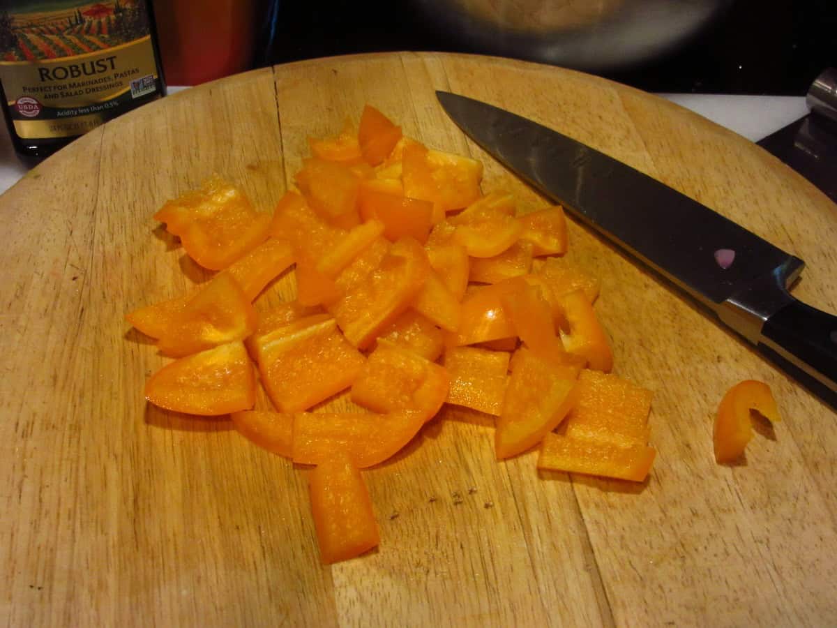 Chopped orange peppers on a cutting board.