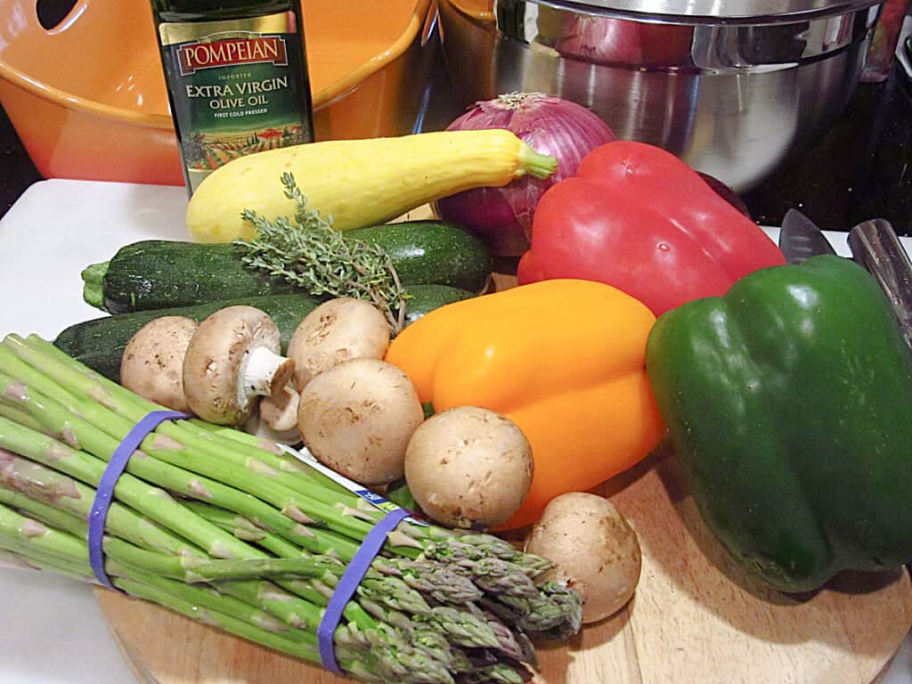 A colorful group of summertime's vegetables on a cutting board.