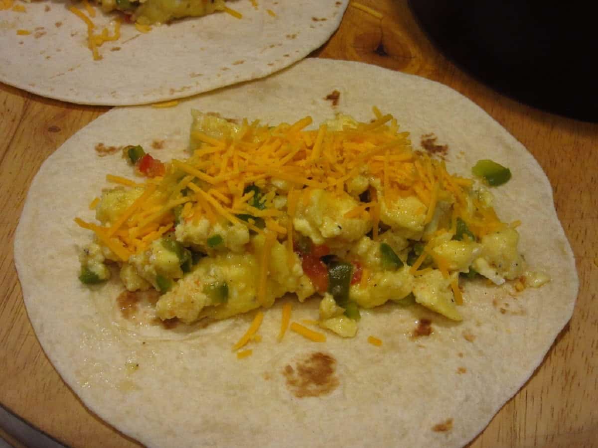 Scrambled eggs and cheese on top of flour tortillas.