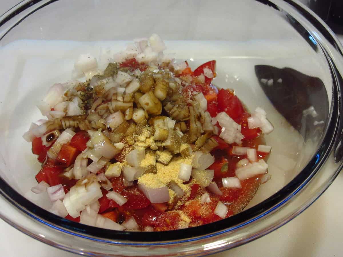 Garlic powder in a bowl of tomatoes and shallots.