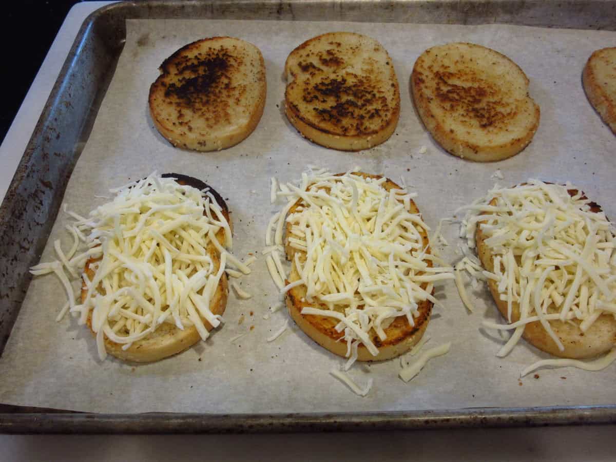 Shredded mozzarella cheese on toasted garlic bread.