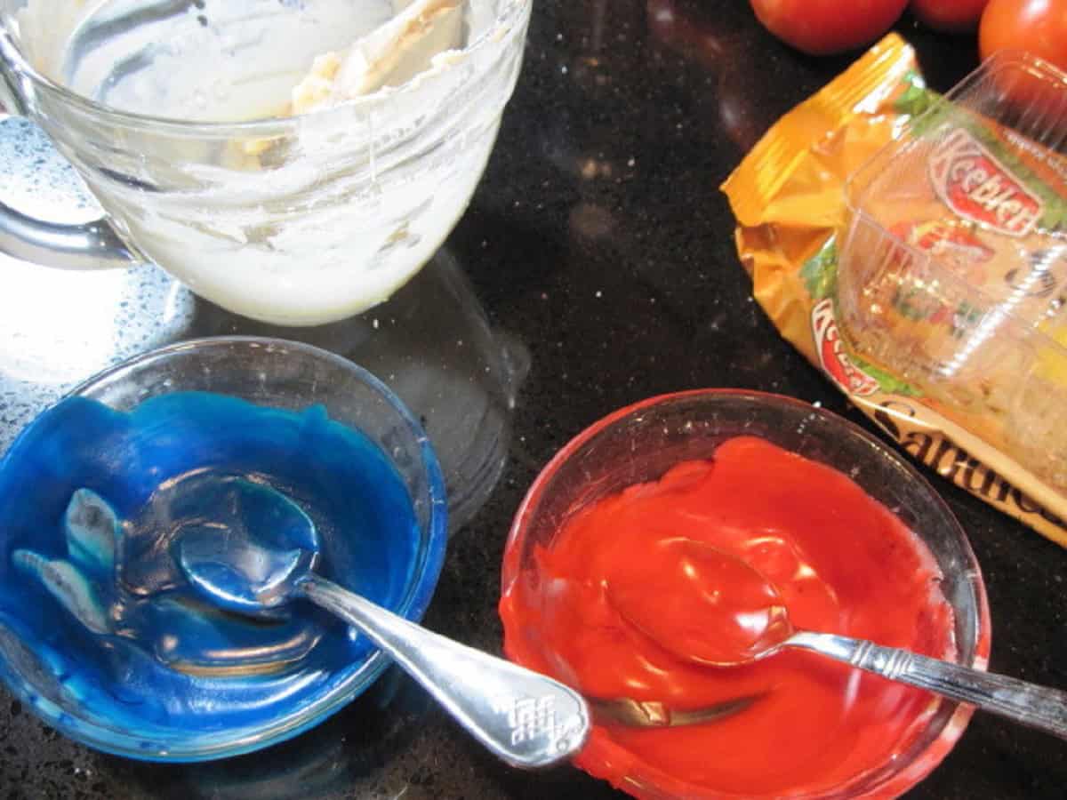 Red and Blue melted chocolate in two small glass bowls.