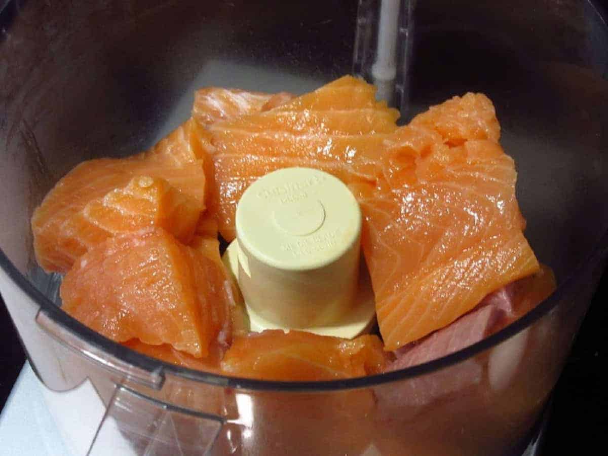 Pieces of salmon in a food processor.