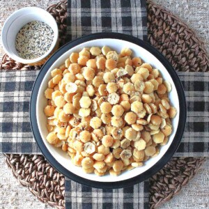 A white bowl filled with Everything Seasoned Oyster Crackers with black and white checkered napkins.