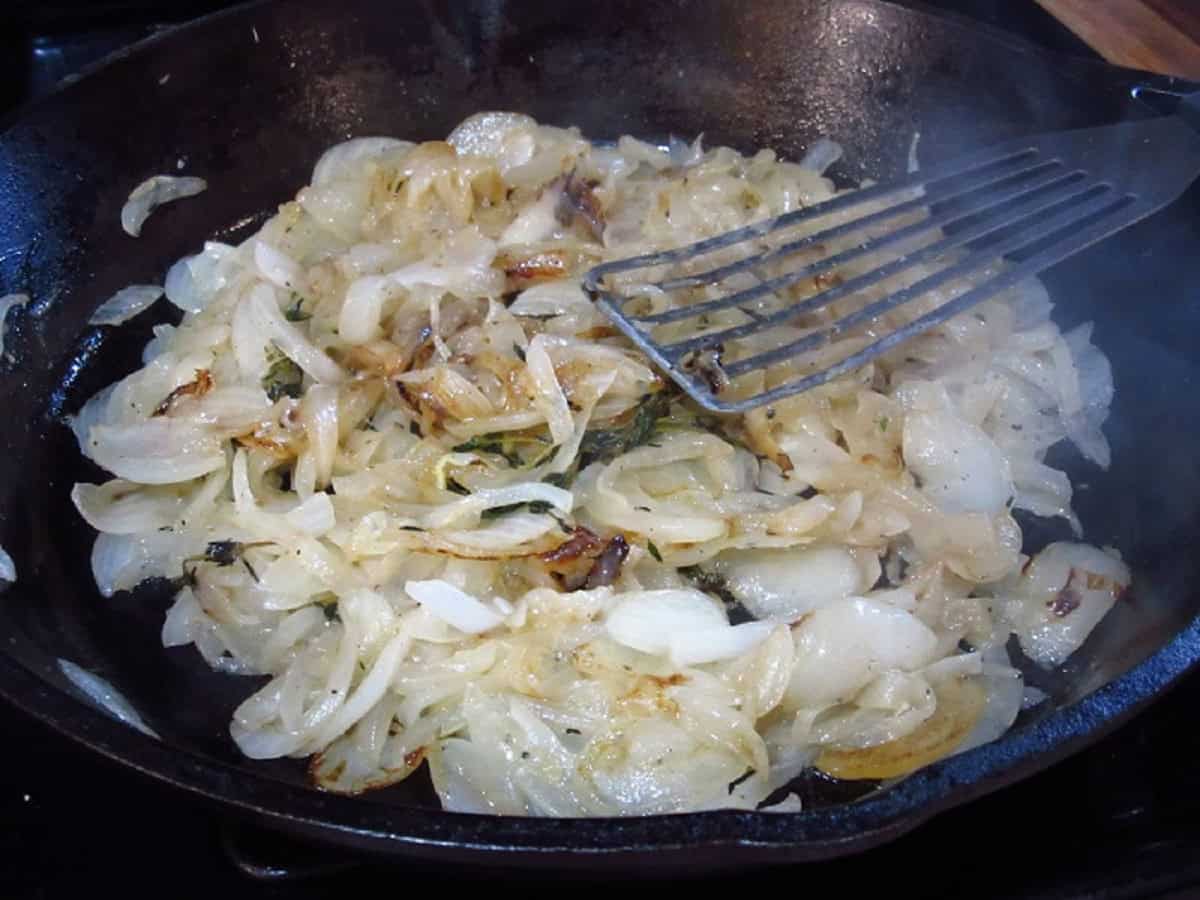 Caramelizing sliced onions in a cast iron skillet.