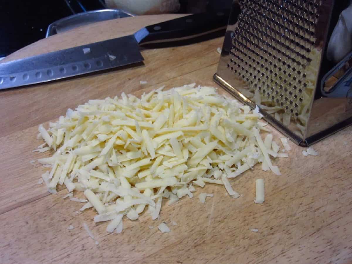 Grated Gruyere cheese with a box grater.