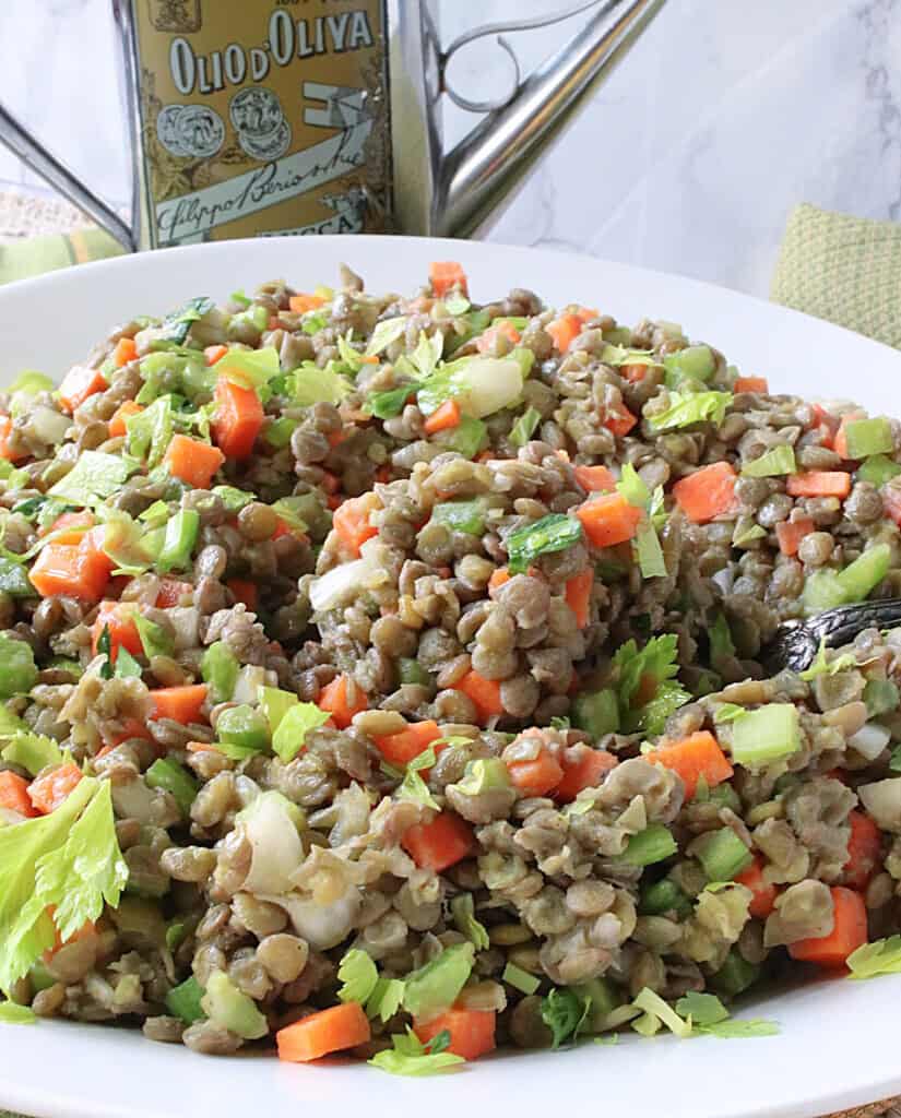 A brown French lentil salad in a white serving bowl.