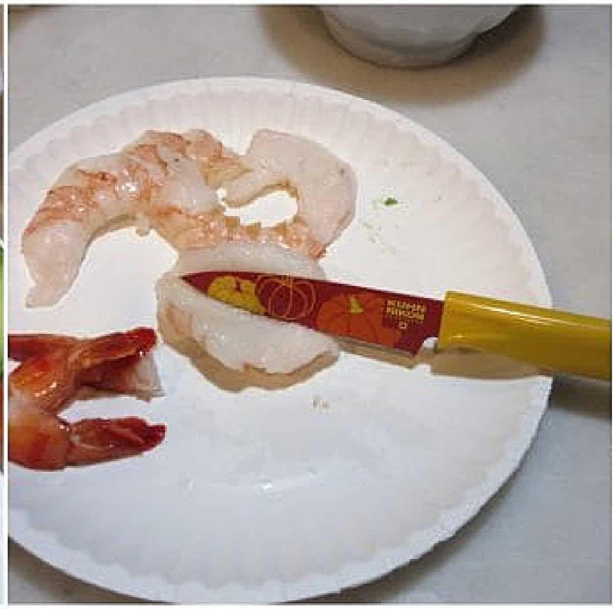 Shrimp and a paring knife on a paper plate.