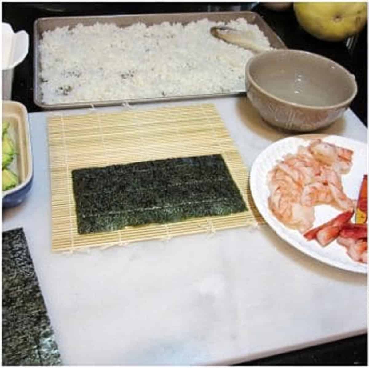 A sushi mat with a nori sheet for making homemade sushi.