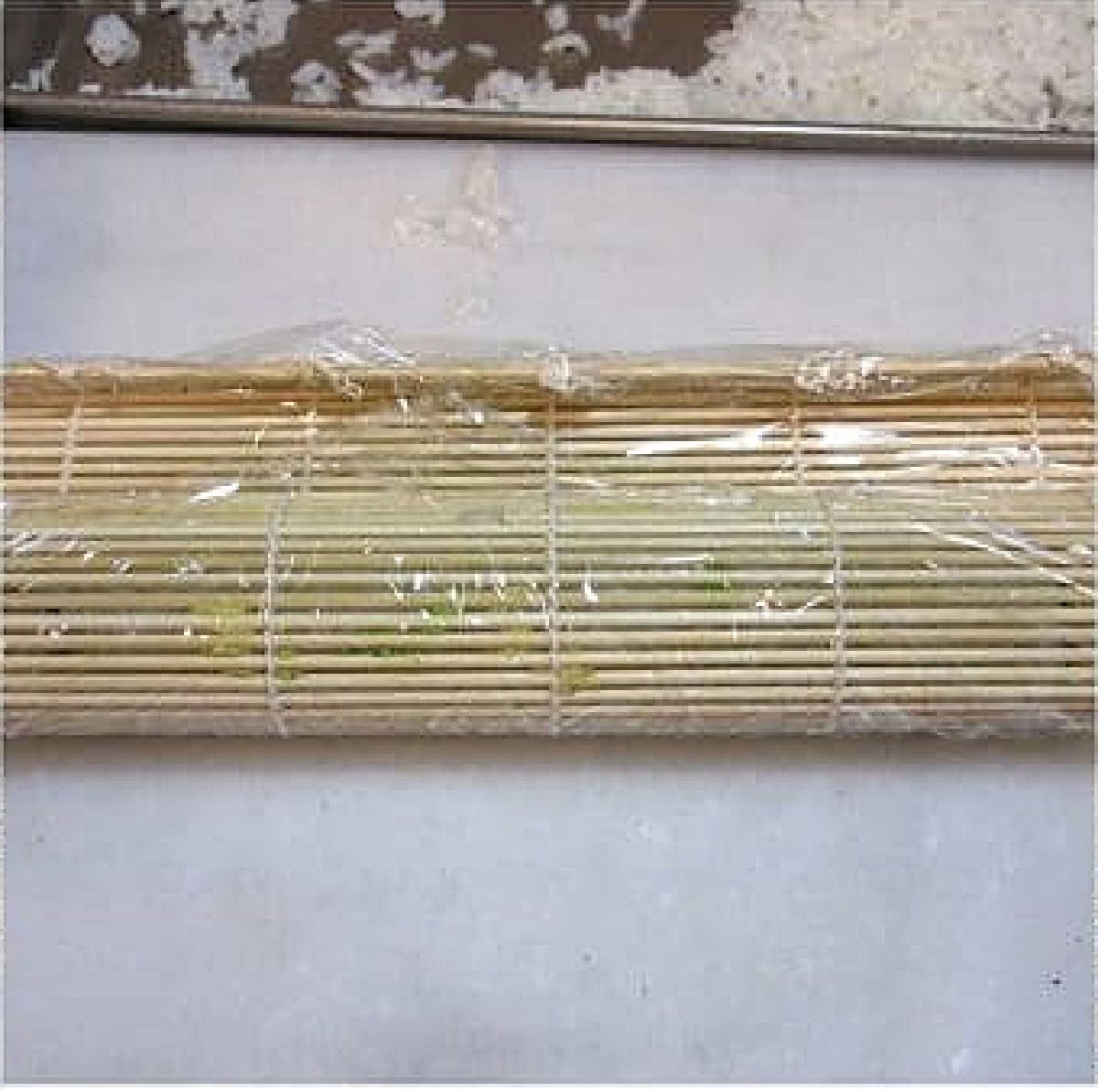 Plastic wrap and a sushi mat making sushi.