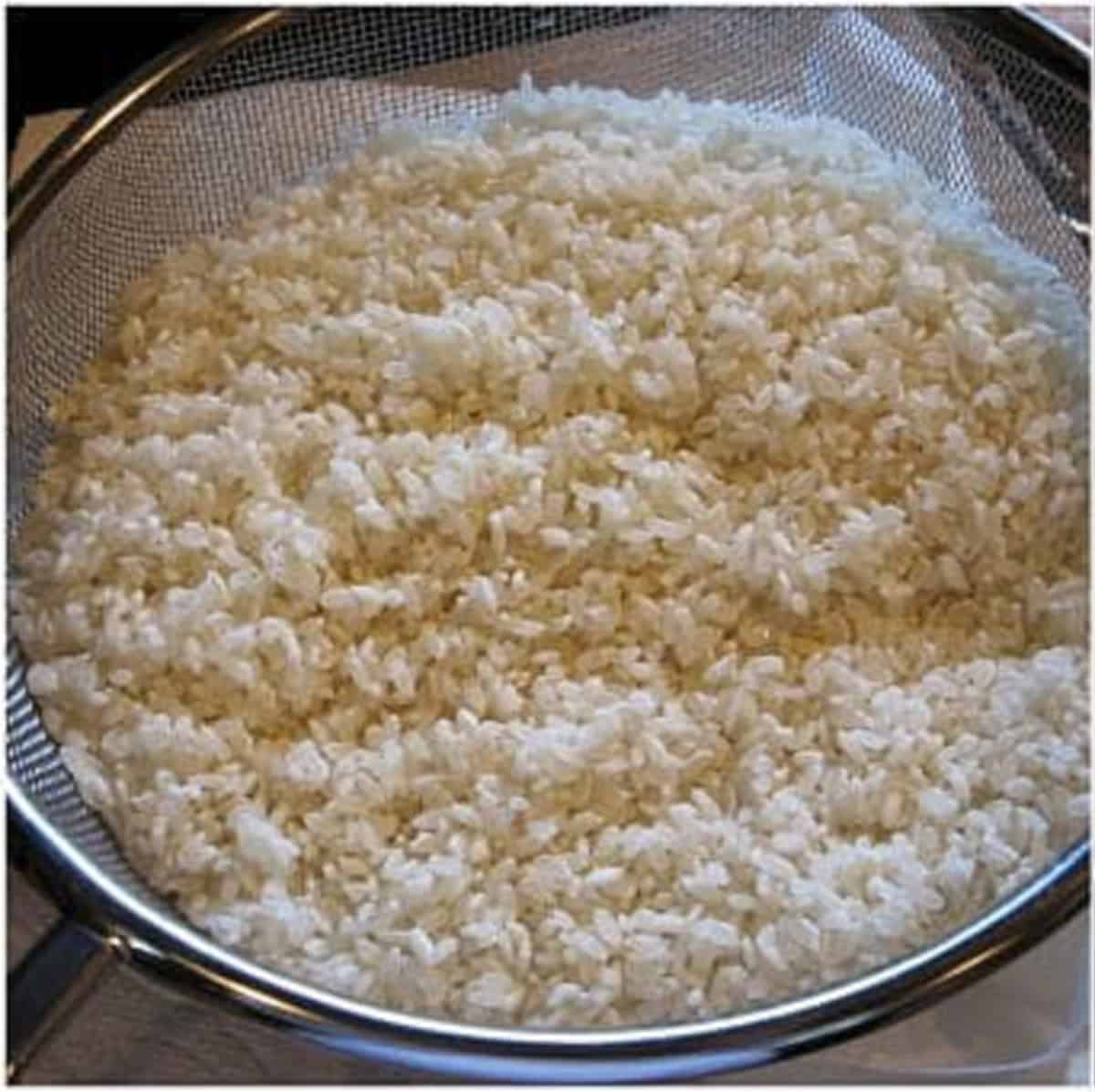 Arborio rice in a strainer.