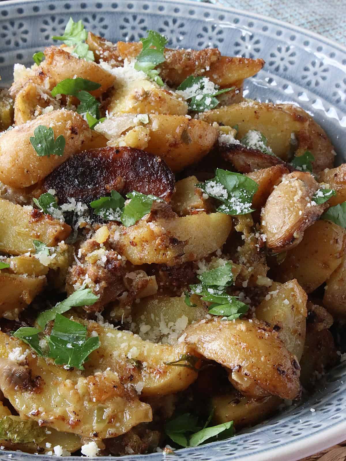 Hot Roasted Potato Salad with garlic and Parmesan cheese in a blue bowl.