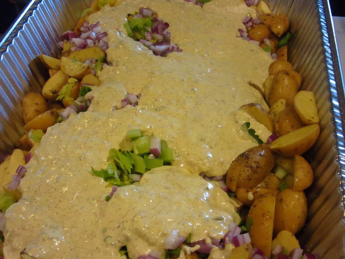 The creamy sauce on top of the chopped potatoes and veggies to make a hot roasted potato salad for a crowd.