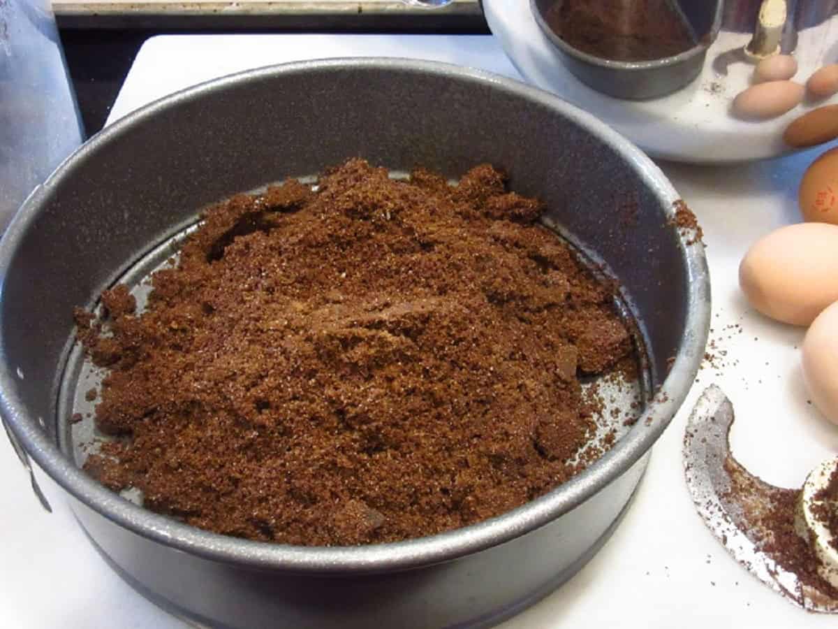 Chocolate graham cracker crumbs in a springform pan.