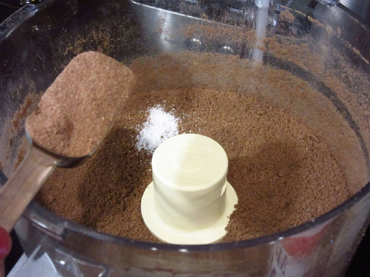 Malted milk ball powder being added to a food processor for making a Whoppers cheesecake.