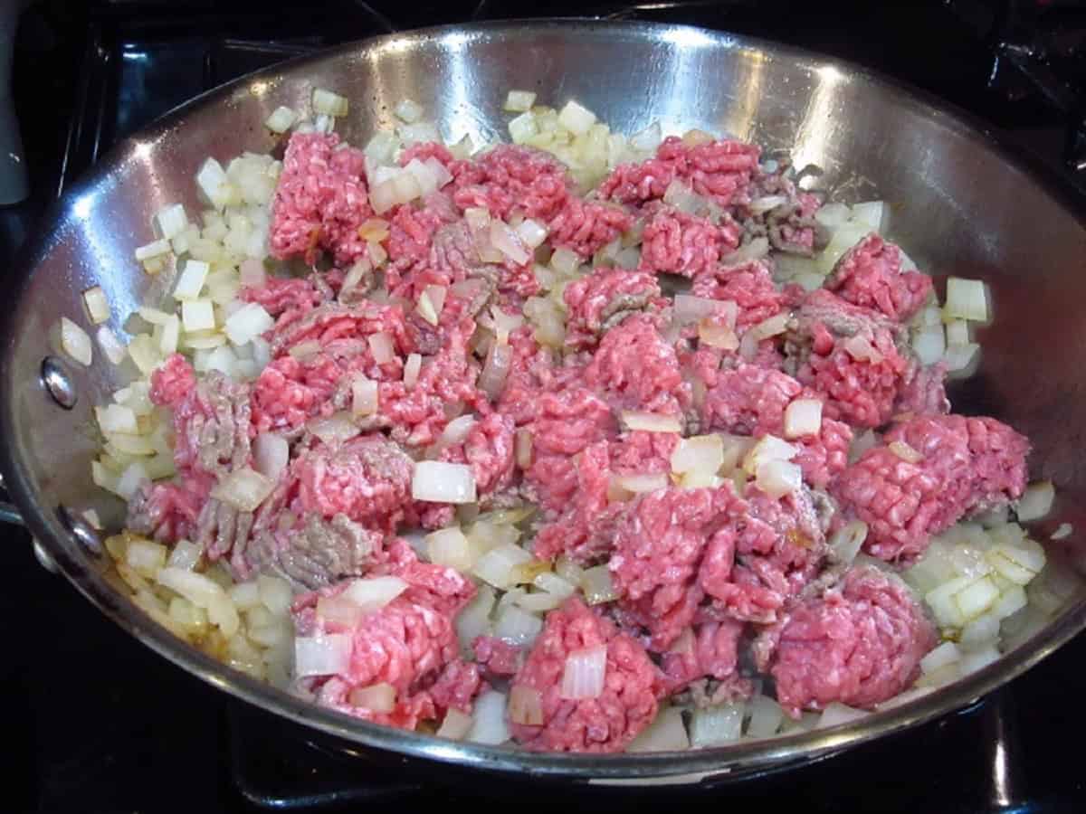 Browning ground beef and onion in a large stainless steel skillet.