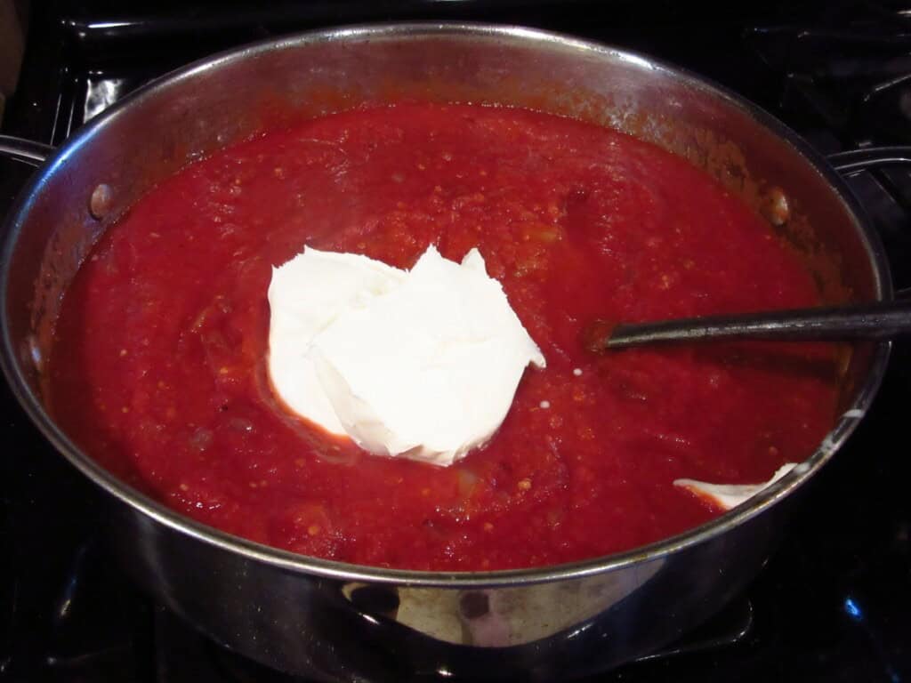 Mascarpone cheese in a skillet with tomato sauce.