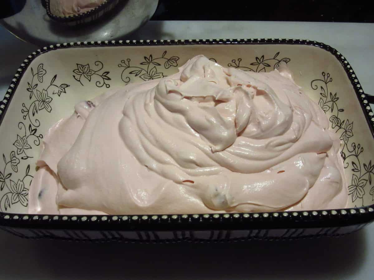 A ceramic baking dish filled with cherry amaretto ice cream base.